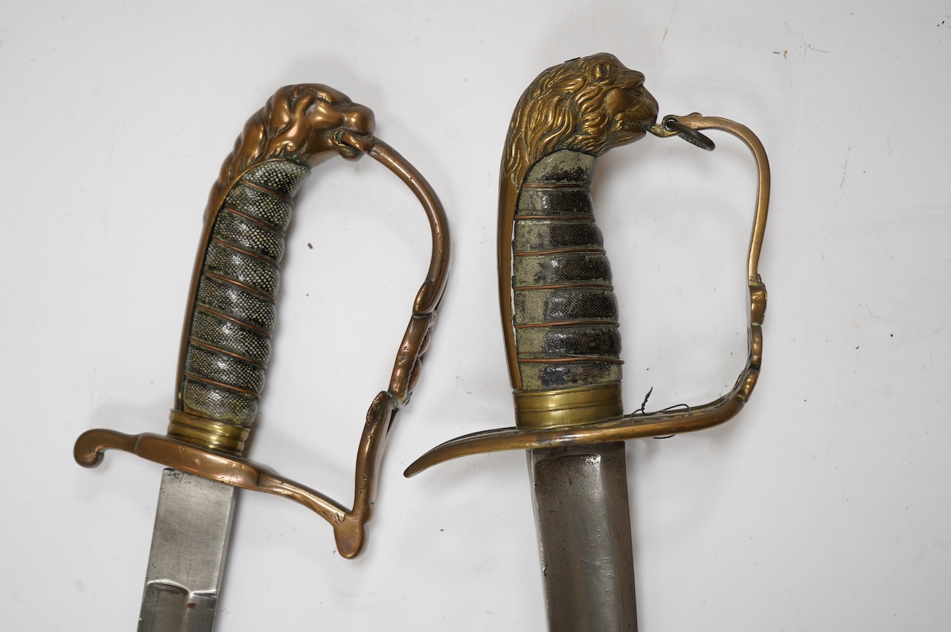 A scarce Scottish Fusiliers NCO‘s sword, with regulation stirrup hilt, regimental badge, lion’s head pommel, wire bound grip, plain blade, together with an 1803 infantry officer’s sword with regulation brass hilt, wire b